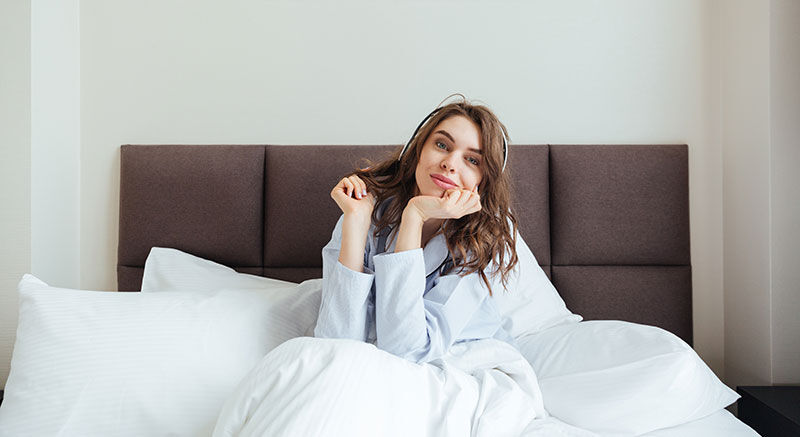 Frau liegt im Boxspringbett