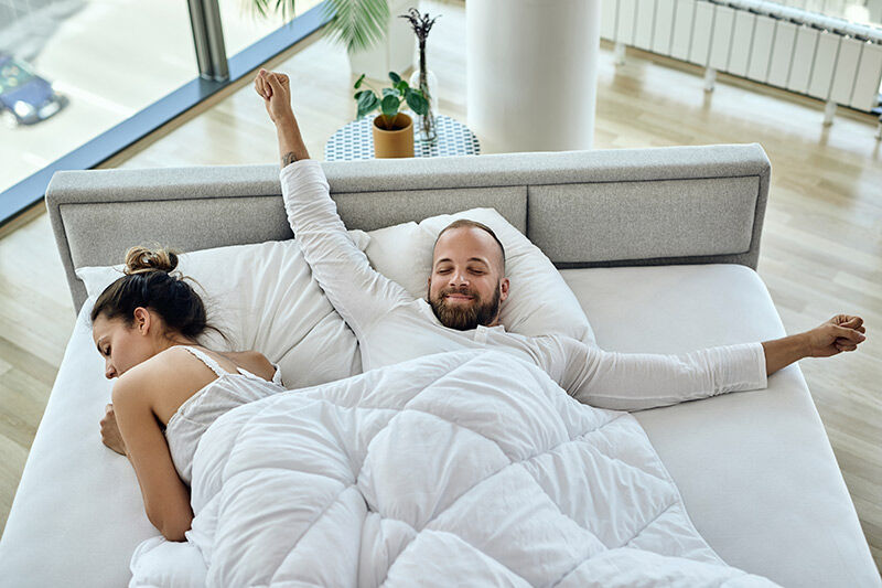 Mann und Frau liegen auf Boxspring Matratzen